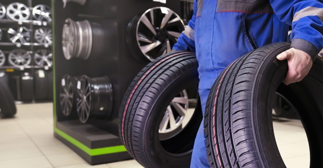 Mechanic carrying vehicle tires. Photo ID 237320416 © Vladimir Razgulyaev | Dreamstime.com